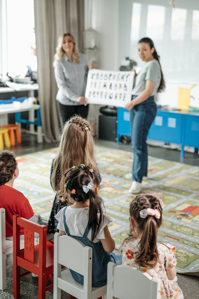 services-03 Young children engaged in a fun alphabet lesson with teachers in a kindergarten classroom.